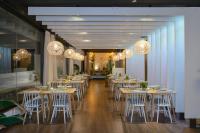 Un comedor con mesas, sillas y candelabros. en Hostal Torrejón, en Torrejón de Ardoz