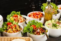 uma mesa repleta de tigelas de salada e uma garrafa de cerveja em Fezinn Hotel - Best Wayanad Hotel in 2024 em Calecute