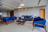 Una sala de estar con sillas azules y una mesa. en Go Inn Betim - MG, en Betim