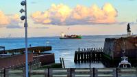 a boat in the water next to a pier at Rijksmonument Havenzicht, met zeezicht, ligging direct aan zee en centrum in Vlissingen