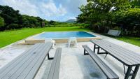 a swimming pool with two benches and a picnic table at Butterfly B&amp;B in Manzhou