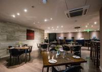 Un restaurante con mesas y sillas en una sala. en Holiday Inn Express New Delhi International Airport T3 by IHG, en Nueva Delhi