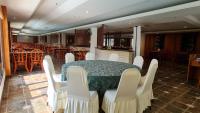 a dining room with a table and white chairs at De Greenish Village Langkawi in Kuah