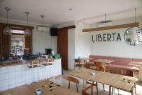 un ristorante con tavoli e sedie e una biblioteca di Liberta Malioboro South a Yogyakarta