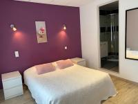 a bedroom with a white bed and a purple wall at Pension Gérard in Bourbonne-les-Bains