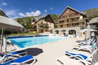 a swimming pool with lounge chairs and a hotel at Logement 4&#47;6 personnes à la montagne avec piscine in Saint-Sorlin-dʼArves