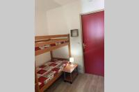 a small bedroom with a bunk bed and a red door at Logement 4&#47;6 personnes à la montagne avec piscine in Saint-Sorlin-dʼArves