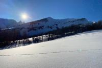a snow covered mountain with the sun in the background at Logement 4&#47;6 personnes à la montagne avec piscine in Saint-Sorlin-dʼArves