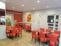 a dining room with tables and orange chairs at Hôtel Hermance in Bellegarde-sur-Valserine