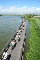 a group of people riding bikes on a bridge over water at Dongshan River Resort Farm in Wujie