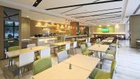 a restaurant with tables and chairs and a bar at Holiday Inn Express Shanghai Gongkang by IHG in Baoshan