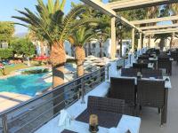 un ristorante con palme e una piscina di Palladium hotel a Marmári