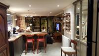 a kitchen with a bar with two stools at a counter at Square Studio in Neuilly-sur-Seine