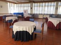 a room with several tables and chairs with white and red tables at HOTEL CRUZ DA MATA in Mangualde