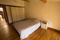 a bedroom with a bed and a wooden floor at Gite d&#39;étape Les Diligences in Roquefixade