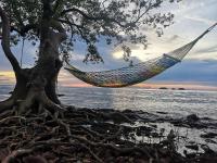 a hammock hanging from a tree on a beach at Koh Chang Bailan Beach Resort in Ko Chang