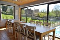 - une salle à manger avec une table, des chaises et de grandes fenêtres dans l'établissement Au Grand Bonheur, à Bessèges