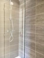 a shower with a glass door in a bathroom at Les Bains Boyardville - Hôtel et Restaurant in Boyard-Ville