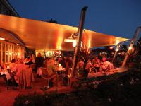 Un grupo de personas sentadas en mesas bajo una carpa. en Gripsholms Värdshus, en Mariefred