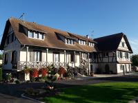 a large white building with a brown roof at Gîtes Au fil des saisons proximité EUROPA PARK in Diebolsheim