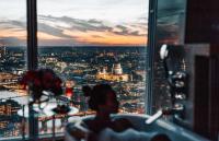 a person is looking out of a window at a city skyline at Shangri-La The Shard, London in London