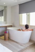 a woman sitting in a bath tub in a bathroom at Meander Taipei Hostel - Ximending in Taipei