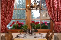 Un comedor con una mesa con flores y ventanas. en Hotel Mesdi, en Arabba
