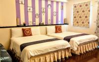 two beds in a room with striped walls at Sweet Rainbow B&amp;B in Hualien City