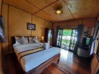 a bedroom with a bed and a television in it at Koh Chang Bailan Beach Resort in Ko Chang