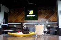 A.M @ 93rd HOTEL في اولونجابو: طبق أصفر عليه قطعة من الكعكة ومشروب