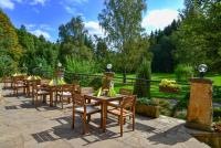 una fila de mesas y sillas en un jardín en Resort Lesní Lázně, en Zvánovice