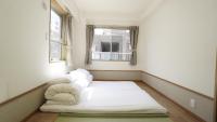 Una cama pequeña en una habitación con ventana. en House Ikebukuro, en Tokio