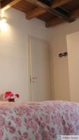 A bed or beds in a room at CaseOspitali - Caramelli, bilocale per 3 in corte in centro storico