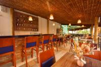 Un restaurante con mesas y sillas y un bar. en Porto das Dunas Boutique Praia Hotel, en Aquiraz