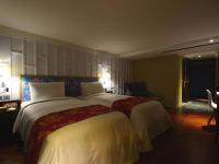 a large bedroom with a large bed with white sheets at Reddot Hotel in Taichung