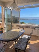 a table and chairs on a balcony with a view of the ocean at Villa Turquoise Sagone in Sagone