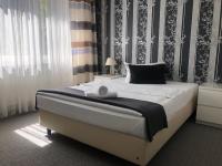1 dormitorio con 1 cama grande y papel pintado en blanco y negro en Hotel Royal Hanau, en Hanau am Main