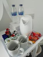 un estante en una nevera con dos tazas y botellas de agua en The Antelope Hotel, en Merthyr Tydfil