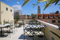 a rooftop patio with tables and a clock tower at Heritage hotel Santa Lucia in Split