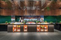 a buffet line with people preparing food in a restaurant at PARKROYAL COLLECTION Marina Bay, Singapore in Singapore