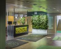 un vestíbulo con una pared verde con plantas en GreenStar Hotel Lahti, en Lahti
