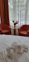 a white towel on a bed with two chairs and a table at Hotel Prahova in Saturn