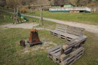 a park with a wooden bench and a playground at chalet du camping la Porte St Martin in Saint-Martin-en-Vercors