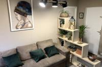 a living room with a couch and shelves with plants at Gite PIPIOU ETAPLES 2 à 4 Personnes in Étaples