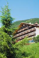 Un gran edificio con árboles delante. en Le Castillan, en L&#39;Alpe-d&#39;Huez