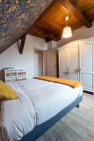 a large bed in a room with wooden ceilings at Gîtes Au fil des saisons proximité EUROPA PARK in Diebolsheim