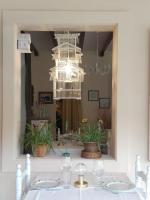 Un espejo de baño con una lámpara de araña sobre un lavabo. en Posada Real Quinta de la Concepción, en Hinojosa de Duero