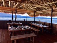 een restaurant met tafels en uitzicht op de oceaan bij TABARI DIVE LODGE in Pulau Mansuar