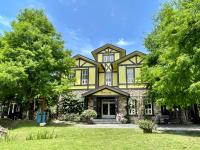 a large yellow house with a porch at Rothenburg Lodge in Wujie