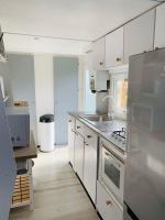 a kitchen with white cabinets and stainless steel appliances at Mobil-home 4 personnes 400m de la mer in Berck-sur-Mer